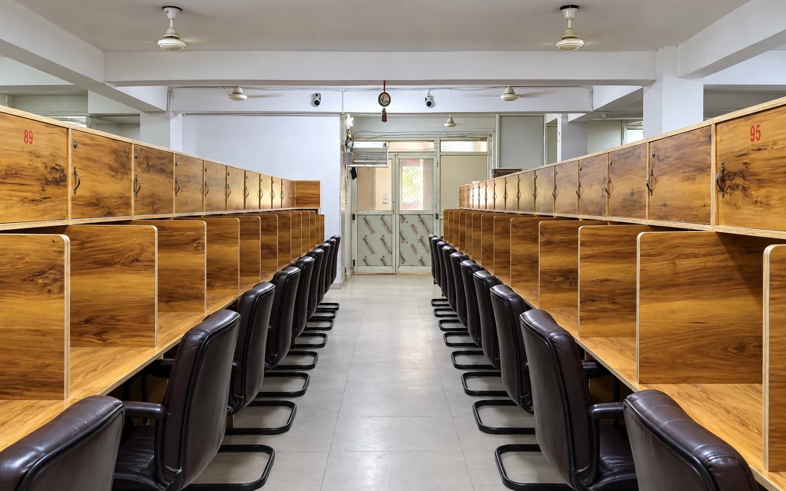 Long aisle of personal wooden cabin desks inside Adhyayan Library in Padav, Gwalior